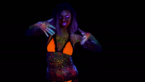 Retrato da bela mulher da moda que dança na luz UV do néon. Menina modelo com maquiagem psicodélica criativa fluorescente, design de arte do modelo de dançarina de disco feminino em UV — Vídeo de Stock