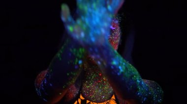 Mor saç Neon Uv ışığında dans ile güzel bir kadın portresi. Model kız floresan yaratıcı Psychedelic makyaj, elini yüzünü önünde Defocused hamle ile.