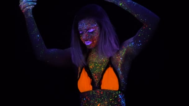 Retrato da bela mulher da moda que dança na luz UV do néon. Menina modelo com maquiagem psicodélica criativa fluorescente, design de arte do modelo de dançarina de disco feminino em UV — Vídeo de Stock