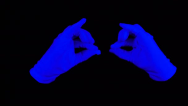 パントマイム パフォーマンスの紫外線手袋。ブラック ライトのシーンで黒い背景に青い手の相互作用. — ストック動画