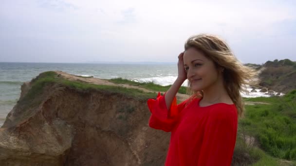 빨간 드레스에 행복 한 젊은 여자는 재미와 바다 해안 절벽에 걷고 — 비디오