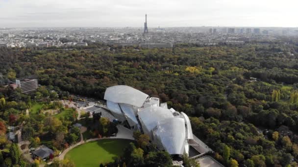 Paris, Fransa 'daki Louis Vuitton Vakfı müzesinin üzerinde uçuyor. Arka planda Eyfel Kulesi, Boulogne Ormanı. — Stok video