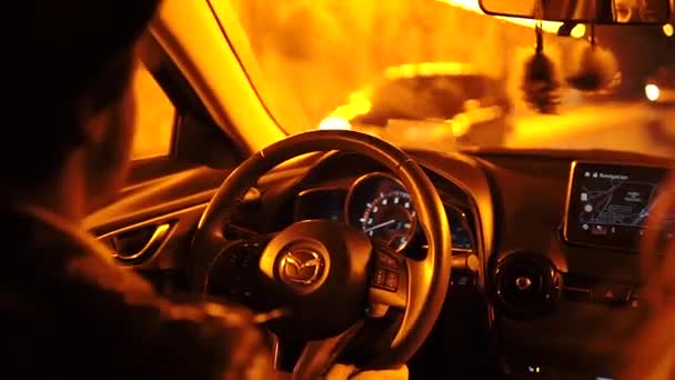 夜にパリで車を運転する帽子のスタイリッシュな男、燃えるような夜の街路灯 — ストック動画