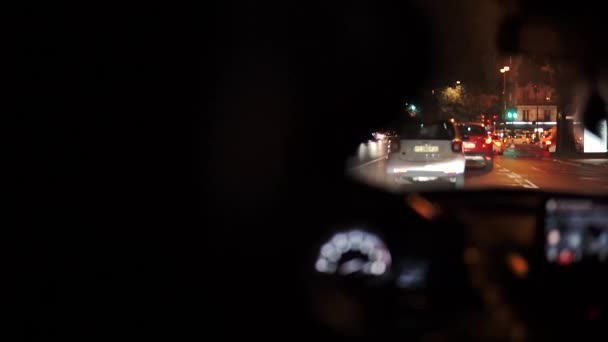 Elegante hombre de sombrero conduciendo un coche en París por la noche, con luces brurred noche de la calle — Vídeo de stock