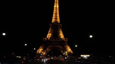 Gimbal, gece Paris 'teki Eyfel Kulesi' ne giderken yol kenarında çekim yaptı. Ilık, büyük metal yapılar.