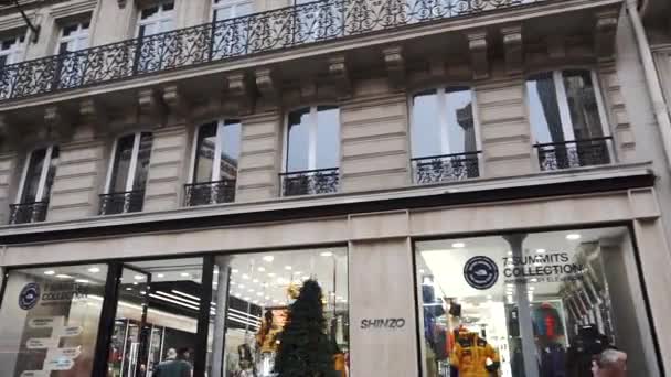 Paris, Frankreich - Oktober 2018: eine typische Pariser Straße entlangfahren. Autos fahren die Straße entlang, Fußgänger gehen auf dem Bürgersteig, französische Boutiquen und Fassaden — Stockvideo