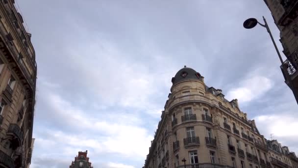 PARIS, FRANÇA - Outubro 2018: Dirigir ao longo de uma rua típica parisiense. Carros estão dirigindo ao longo da estrada, pedestres estão andando ao longo da calçada, Boutiques franceses e fascades — Vídeo de Stock