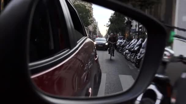 Paris, France- October 2018: View on a car side mirror (англійською). Їдучи вздовж типової паризької вулиці. Машини їдуть по дорозі. — стокове відео