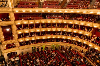 Viyana, Avusturya - Ekim 2019: Ziyaretçilerle birlikte Viyana Devlet Opera Salonu Performans Salonu. Wiener Staatsoper merdivenleri, yuvarlak virajlı koltuklar seyirciler.