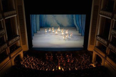 Viyana, Avusturya - Ekim 2019: Ziyaretçilerle birlikte Viyana Devlet Opera Salonu Performans Salonu. Wiener Staatsoper merdivenleri, bale dansçıları ve orkestra