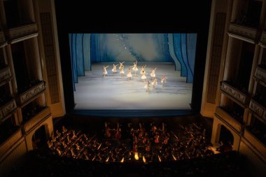 VIENNA, AUSTRIA - OCTOBER 2019: Interior of Vienna State Opera House Performance hall with visitors. Wiener Staatsoper stairs, ballet dancers and orchestra clipart