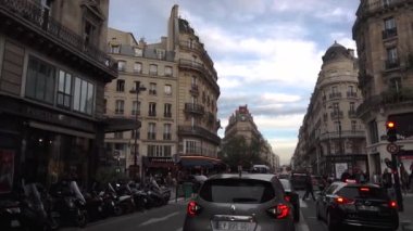 Paris, Fransa - Ekim 2018: Tipik bir Paris caddesi boyunca araba sürmek. Arabalar yol boyunca ilerliyor, yayalar kaldırım boyunca yürüyor, Fransız butikleri ve faşistler.