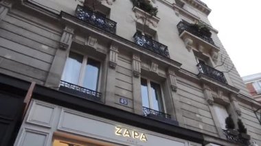 Paris, Fransa - Ekim 2018: Tipik bir Paris caddesi boyunca araba sürmek. Arabalar yol boyunca ilerliyor, yayalar kaldırım boyunca yürüyor, Fransız butikleri ve faşistler.