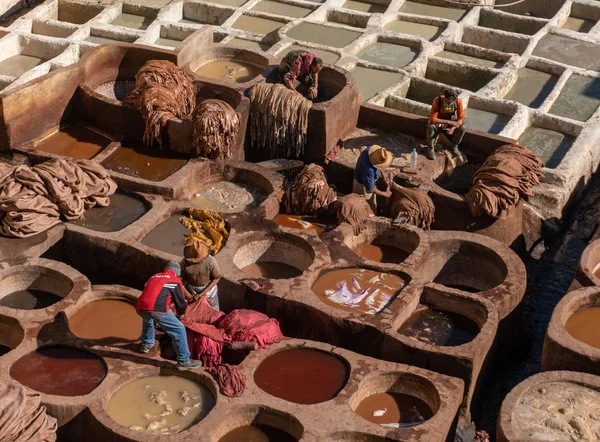 Μαρόκο, Φεξ - Ιανουάριος 2019: Άντρας που εργάζεται στο βυρσοδεψείο Chouara στην παλιά Μεντίνα της Φεζ, ένα παραδοσιακό και παλιό βυρσοδεψείο με εργάτες που εργάζονται με μεθόδους κατασκευής δέρματος — Φωτογραφία Αρχείου