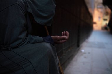Geleneksel Fas kapüşonlu djellaba kıyafetli fakir bir dilenci. Fokiya, jellaba. Sokaktaki isimsiz zavallı dilenci, Fas