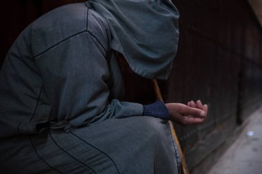 Geleneksel Fas kapüşonlu djellaba kıyafetli fakir bir dilenci. Fokiya, jellaba. Sokaktaki isimsiz zavallı dilenci, Fas