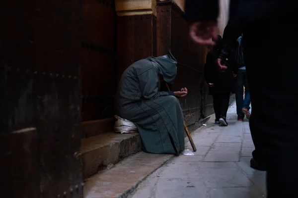 Un povero mendicante in abito tradizionale marocchino con cappuccio djellaba. fokiya, jellaba. Povero mendicante anonimo per strada, Marocco — Foto Stock