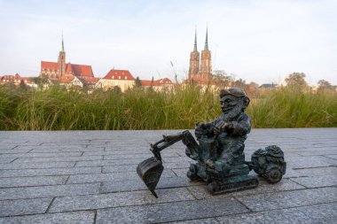Bronz cüce, Odra nehrinin kabartmalarında ve arka planında ostrow tumski var. Wroclaw 'da 600' den fazla cüce var.