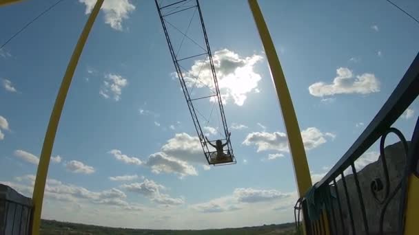 Lány lovaglás óriás swing a sziklán a kék tó felett a karrier — Stock videók