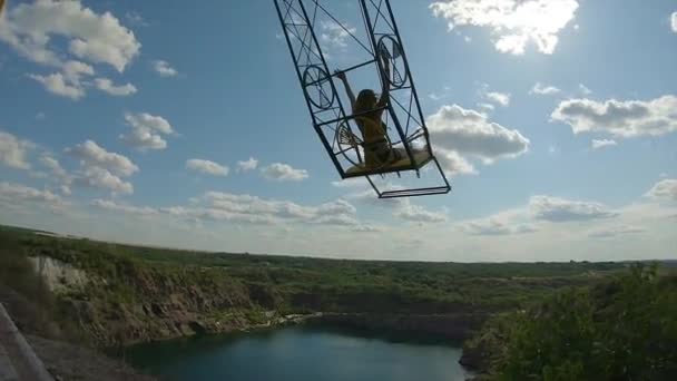 Dziewczyna jazda na Giant huśtawka na klifie nad błękitnym jeziorem w karierze — Wideo stockowe