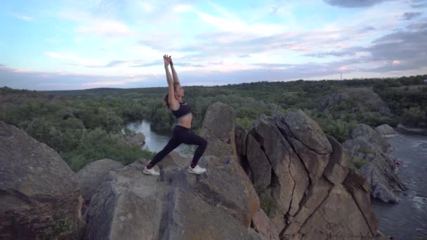 Sporty woman practicing yoga and gymnastics exercises on mountain cliff with beautiful landscape ob background. Healthy lifestyle. active extreme. — Stok video