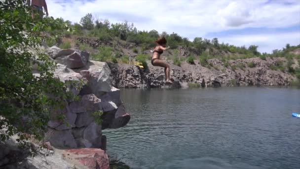 Aziatisch rood hoofd jonge mooie meisjes springen van een klif in het meer. Langzame beweging Gopro schot — Stockvideo