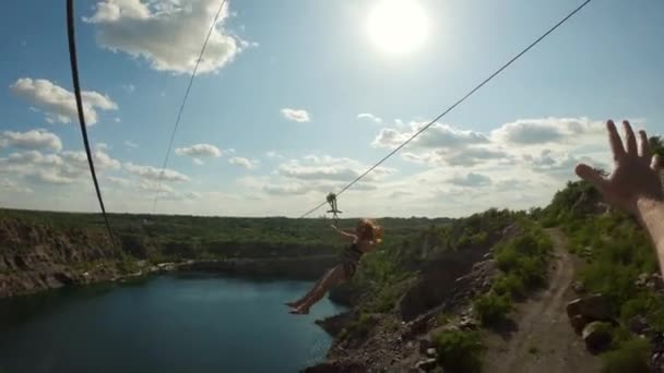 POV shot of zipline trolley above the lake action leisure with girl couple extreme vacation — ストック動画