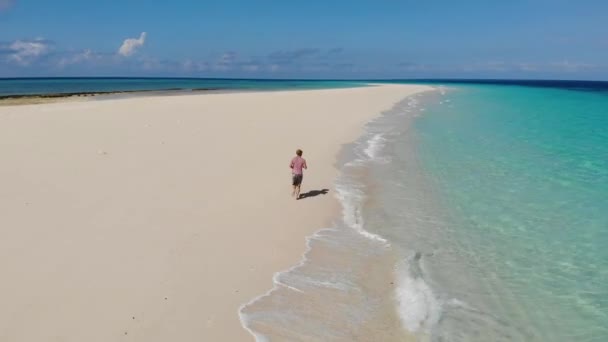 Zanzibar. Sportovní muž běžící podél břehu na sněhobílém písečném břehu ostrova Nakupenda. Objevuje se jen pár hodin denně. Výstřel ze vzdušného letounu — Stock video