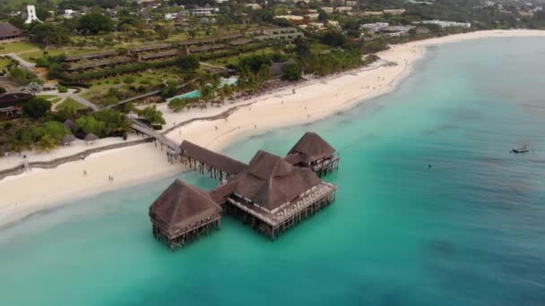 Gyönyörű nádtetős stilt ház Zanzibar Nungwi strand este, kék indiai óceán légi kilátás — Stock videók