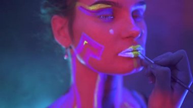 Neon UF Light 'ta Dreadlock' lu bir kız uydurmak. Flüoresan Yaratıcı Psikedelik Makyajlı Model Kız, UV 'deki Kadın Disko Dansçısı Modeli, Renkli Soyut Makyaj. Dans eden bayan.