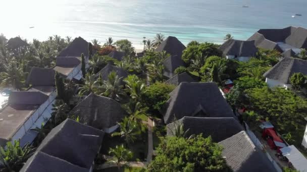 Vista aérea de telhados cobertos de luxo Resort com Oceano na bela costa do oceano de areia branca em Nungwi na ilha de Zanzibar, na Tanzânia — Vídeo de Stock