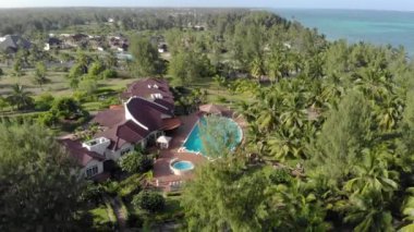 Tanzanya 'nın Zanzibar adasındaki Paje' de bulunan güzel beyaz kumlu okyanus kıyısındaki Thatched okyanus manzaralı otelin hava manzarası.