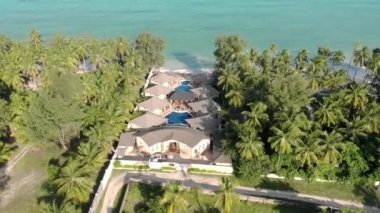 Tanzanya 'nın Zanzibar adasındaki Paje' de bulunan güzel beyaz kumlu okyanus kıyısındaki Thatched okyanus manzaralı otelin hava manzarası.