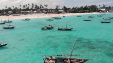 Zanzibar 'daki güzel tropikal kıyı şeridi yakınlarındaki geleneksel Unguja Dhow teknelerine hava aracı saldırısı. Nungwi plajı bir günde mavi Hint okyanusuyla
