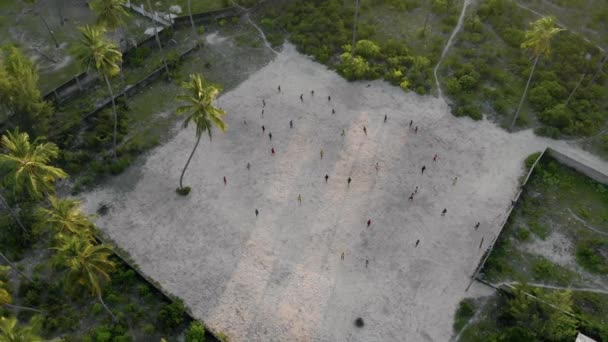 Flying above the guys playing Football on the footbal field in Tanzanian Paje village at East Zanzibar island aerial view. Tanzania, Africa — Stock Video