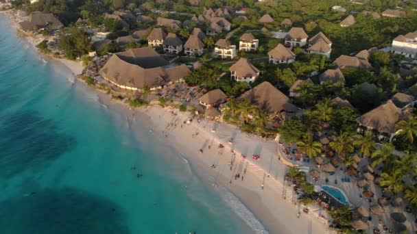 Luftaufnahme des reetgedeckten Daches des luxuriösen Ocean View Resorts an der wunderschönen weißen Sandmeerküste in Nungwi Beach Abendsonnenuntergang auf der Insel Sansibar, Tansania — Stockvideo