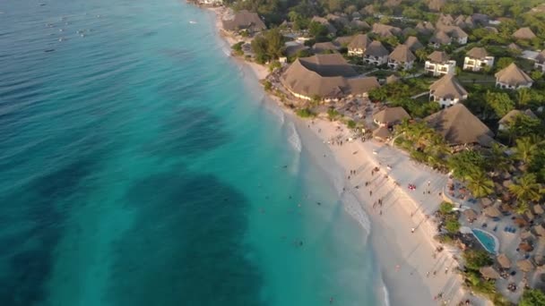 Luftaufnahme des reetgedeckten Daches des luxuriösen Ocean View Resorts an der wunderschönen weißen Sandmeerküste in Nungwi Beach Abendsonnenuntergang auf der Insel Sansibar, Tansania — Stockvideo