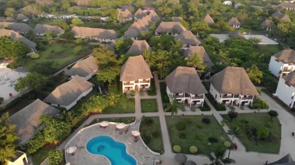 Aerial view of Thatched roof of luxury ocean view resort at the beautiful white sand ocean coast in Nungwi Beach Evening Time Sunset at Zanzibar island, Tanzania — Stock Video