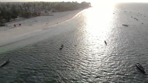 Aerial Drone strzał na tradycyjnych łodzi Unguja Dhow w pobliżu pięknej tropikalnej linii brzegowej na Zanzibar. Plaża Nungwi w ciągu dnia z błękitnym Oceanem Indyjskim — Wideo stockowe