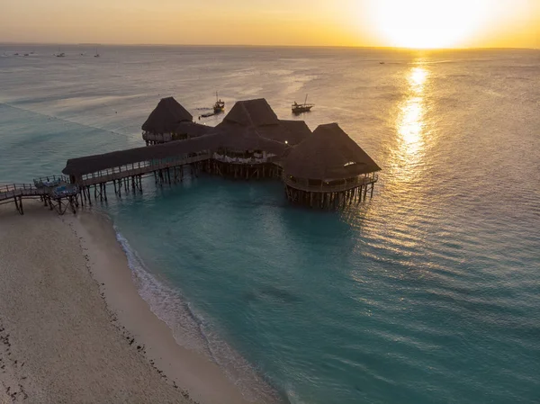 Hint okyanusunun Turkuaz Suyu 'nda akşam saatlerinde Zanzibar Kendwa plajındaki Güzel Thatch stilt ev restoranında Top View.