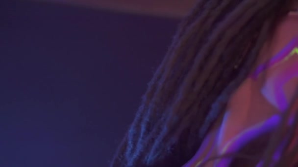 Portretul unei fete cu Dreadlocks în Neon UF Light. Model Girl dans cu un LED împrumutat este ochelari de soare roșu, Design de artă a feminin Disco Dancer model în UV, colorate Abstract make-up . — Videoclip de stoc