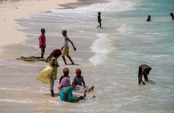 Nungwi, Zanzibar - 2019 년 12 월 : Boys and Girls in Turquoise Water. 탄자니아 잔지바르 북부응 위 마을의 순니 데이에 있는 아프리카 어린이들, 해변에서 노는 모습 — 스톡 사진