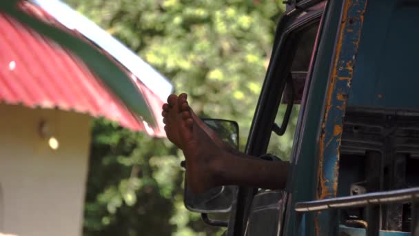 Pies de negro negro descansando hombre esparcido en la ventana de la cabina de camiones — Vídeos de Stock