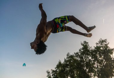 Beyaz Kum Sahili Akrobatik Eğitimi ve Atlayan Jimnastik Sahili Performansında Genç Çekici Kaslı ve Güçlü Siyah Afrikalı Adam