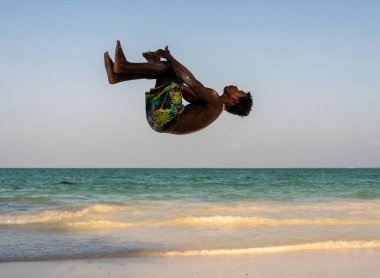Beyaz Kum Sahili Akrobatik Eğitimi ve Atlayan Jimnastik Sahili Performansında Genç Çekici Kaslı ve Güçlü Siyah Afrikalı Adam