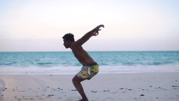 Young Attractive Muscular and Strong Athletic Black African Man trainiert Akrobatik und Sprungturnen bei der White Sand Beach Performance — Stockvideo