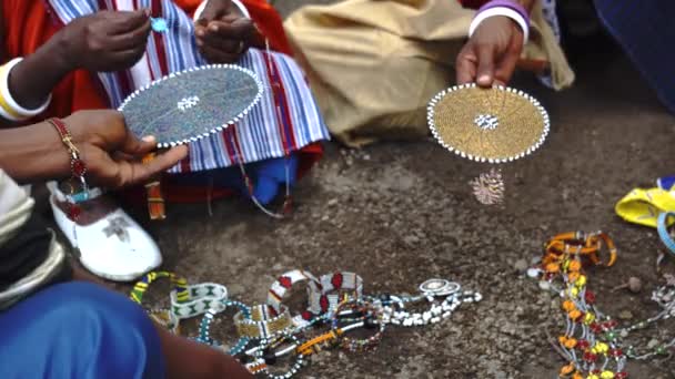 Hands of Masai Kvinnor med traditionella smycken säljer sina hemmagjorda souvenirer bara på marken Visar dem för turister och resenärer — Stockvideo