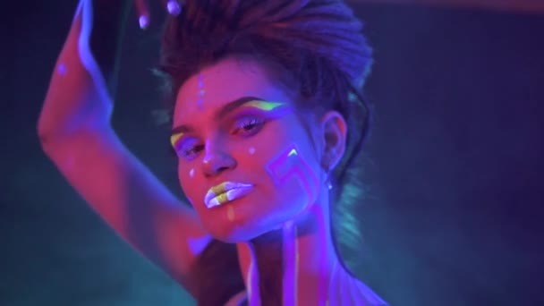 Portrait of a Girl with Dreadlocks in Neon UF Light. Model Girl with Fluorescent Creative Psychedelic MakeUp, Art Design of Female Disco Dancer Model in UV, Colorful Abstract Make-Up. Dancing Lady — Stock Video
