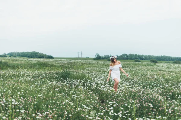 Uma menina em um campo de camomilas — Fotografia de Stock