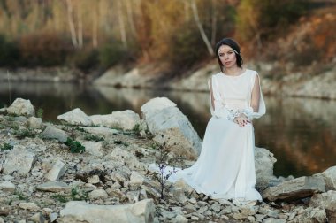 Bir göl kıyısında beyaz elbiseli bir kız